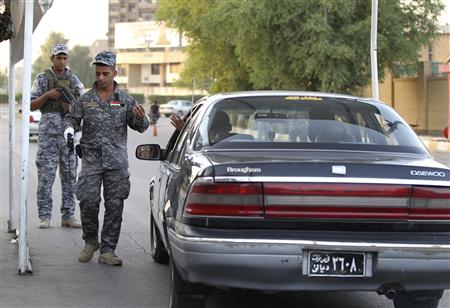 Des policiers contrôlent un véhicule, à Bagdad, le 23 octobre 2010